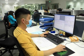 Nhân viên văn phòng Công ty trách nhiệm hữu hạn sản xuất hàng may mặc Việt Nam tại Khu công nghiệp Bá Thiện 2 đeo khẩu trang khi làm việc. (Ảnh: Hoàng Hùng/TTXVN)