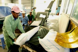 Bốc xếp gạo xuất khẩu. (Nguồn: TTXVN)