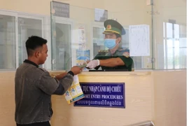 Bộ đội Biên phòng tỉnh An Giang làm thủ tục xuất cảnh đối với cư dân qua lại biên giới tại Trạm kiểm soát liên hợp cửa khẩu quốc tế Tịnh Biên (Tịnh Biên, An Giang). (Ảnh: Công Mạo/TTXVN)