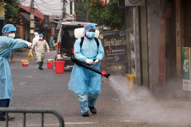 Lực lượng chức năng phun khử khuẩn tại thôn Hạ Lôi (Mê Linh). (Ảnh: Phạm Hùng/TTXVN phát)