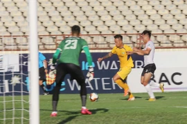 Pha tranh bóng giữa cầu thủ Sông Lam Nghệ An và Bình Định. (Ảnh: Nguyễn Oanh/TTXVN)