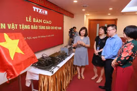 Ông Lê Quốc Minh, Phó Tổng Giám đốc, Chủ tịch Liên Chi hội Nhà báo TTXVN cùng các đại biểu tham quan các hiện vật quý về Báo chí Việt Nam. (Ảnh: Thành Đạt/TTXVN)