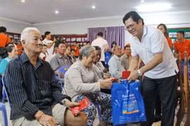Ông Lê Văn Ron, Phó Tổng giám đốc Sacombank tặng quà cho bà con gốc Việt tại trụ sở Hội Khmer-Việt Nam. (Ảnh: Nguyễn Hùng/Vietnam+)