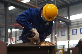 Công nhân làm việc tại nhà máy ở Tương Dương, tỉnh Hồ Bắc, Trung Quốc ngày 23/3/2020 trong bối cảnh dịch COVID-19 lan rộng. (Nguồn: THX/TTXVN)