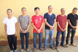 Các đối tượng trong băng nhóm “Dọn sạch nhà” tại cơ quan công an. (Ảnh: Đậu Tất Thành/TTXVN) 