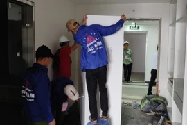 Lực lượng cưỡng chế tháo dỡ các thiết bị tại tầng 18 tòa nhà vi phạm trật tự xây dựng tại 8B Lê Trực. (Nguồn: TTXVN phát)