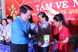 Ông Kiều Ngọc Vũ, Phó Chủ tịch Liên đoàn Lao động Thành phố Hồ Chí Minh trao vé xe về quê ăn Tết cho công nhân. (Ảnh: Xuân Anh/TTXVN)