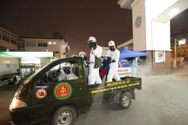 Lực lượng bộ đội hóa học phun hóa chất khử khuẩn khu vực cổng số 1 Bệnh viện Bạch Mai. (Ảnh: Dương Giang/TTXVN)