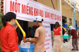 Người dân đến nhận gạo tại điểm "ATM gạo" phường Phước Tiến, mỗi người nhận 2 kg gạo/ngày. (Ảnh: Tiên Minh/TTXVN)