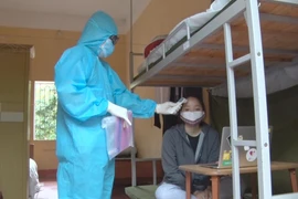 Đo thân nhiệt cho công dân thực hiện cách ly tập trung ở Hưng Yên. (Nguồn: TTXVN)