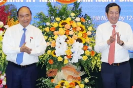 Thủ tướng Nguyễn Xuân Phúc tặng hoa chúc mừng ông Thuận Hữu, Ủy viên Trung ương Đảng, Tổng Biên tập Báo Nhân Dân, Phó Trưởng Ban Tuyên giáo Trung ương, Chủ tịch Hội Nhà báo Việt Nam. (Ảnh: Thống Nhất/TTXVN)