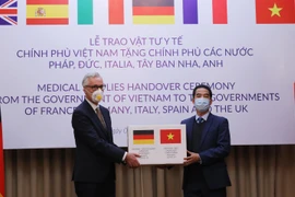 Thừa ủy quyền của Thủ tướng Chính phủ, Thứ trưởng Bộ Ngoại giao Tô Anh Dũng trao hàng hỗ trợ của Việt Nam đến Đại sứ Cộng hòa Liên bang Đức tại Việt Nam Guido Hildner. (Ảnh: Lâm Khánh/TTXVN)