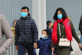 Người dân Thủ đô ra đường chơi Tết với khẩu trang y tế đề phòng virus corona. (Ảnh: Thành Đạt/TTXVN)