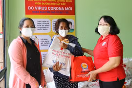 Hội Chữ thập đỏ Quận 3, Thành phố Hồ Chí Minh trao quà cho người bán vé số dạo bị ảnh hưởng dịch bệnh COVID-19. (Ảnh: Thanh Vũ/TTXVN)