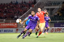 Pha tranh bóng giữa cầu thủ đội bóng Sài Gòn FC (áo tím) và đội bóng Hồng Lĩnh Hà Tĩnh (áo đỏ). (Ảnh: Thanh Vũ/TTXVN)
