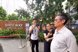 Phóng viên phỏng vấn người dân tại cổng trường Quốc tế Gateway. (Ảnh: Thành Đạt/ TTXVN)