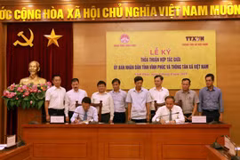 Tổng Giám đốc Thông tấn xã Việt Nam Nguyễn Đức Lợi (trái) và Phó Bí thư Tỉnh ủy, Chủ tịch UBND tỉnh Vĩnh Phúc Nguyễn Văn Trì ký thỏa thuận hợp tác. (Ảnh: Hoàng Hùng/TTXVN)