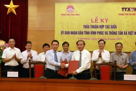 Tổng Giám đốc Thông tấn xã Việt Nam Nguyễn Đức Lợi (trái) và Phó Bí thư Tỉnh ủy, Chủ tịch UBND tỉnh Vĩnh Phúc Nguyễn Văn Trì ký thỏa thuận hợp tác. (Ảnh: Hoàng Hùng/TTXVN)