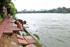 Nhiều vị trí đã mất chân kè dẫn đến hệ thống đường dạo sát mép hồ nhiều điểm bị lún sụt, gây nguy hiểm cho người dân và khách du lịch. (Ảnh: Minh Quyết/TTXVN)