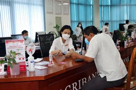 Giao dịch tại Ngân hàng Nông nghiệp và phát triển nông thôn. (Ảnh: Cao Nguyên/TTXVN)