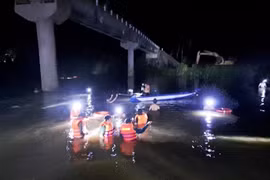 Gia đình, chính quyền địa phương, người dân và lực lượng chức năng nỗ lực tìm kiếm các nạn nhân trong đêm. (Ảnh: TTXVN phát)
