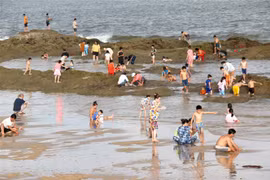 Du khách tắm biển tại bãi biển Thương Chánh, thành phố Phan Thiết. (Ảnh: Nguyễn Thanh/TTXVN)