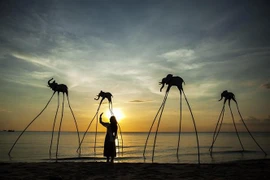 Du khách trải nghiệm không gian hoàng hôn trên Bãi Trường, nơi được cho là địa điểm ngắm hoàng hôn đẹp nhất Việt Nam. (Ảnh: Hồng Đạt/TTXVN)