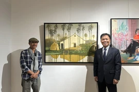 Đại sứ Việt Nam tại Mông Cổ Doãn Khánh Tâm chụp ảnh lưu niệm cùng tác giả bên tác phẩm. (Nguồn: Đại sứ quán Việt Nam tại Mông Cổ)