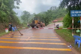 Lực lượng chức năng lập rào chắn cấm xe lưu thông qua cầu Nậm Nhé. (Ảnh: TTXVN phát)