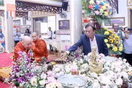 Nghi lễ tắm Phật cầu an cho năm mới. (Ảnh: Xuân Khu/TTXVN)