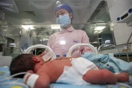 Nhân viên y tế chăm sóc em bé sơ sinh tại Trung Quốc. (Ảnh minh họa. Nguồn: AFP/TTXVN)
