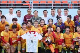 Thủ tướng Phạm Minh Chính chụp ảnh lưu niệm với các cầu thủ và Ban Huấn luyện, các thành viên của Đội tuyển Bóng đá Nữ Quốc gia Việt Nam. (Ảnh: Dương Giang/TTXVN) 