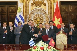 Chủ tịch Quốc hội Nguyễn Sinh Hùng và Chủ tịch Hạ viện Cộng hòa Đông Uruguay Anibal Pereyra ký Thỏa thuận hợp tác giữa Quốc hội hai nước (Hà Nội, 19/1/2015). (Ảnh: Nhan Sáng/TTXVN)