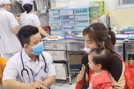 Khám cho trẻ mắc bệnh tay chân miệng. (Ảnh: TTXVN phát)
