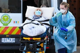 Nhân viên y tế chuyển bệnh nhân COVID-19 tại Melbourne, Australia. (Ảnh: AFP/TTXVN)
