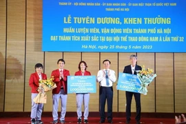 Bí thư Thành ủy Hà Nội Đinh Tiến Dũng trao thưởng của thành phố tặng Đoàn Thể thao Hà Nội tham dự Đại hội Thể thao Đông Nam Á lần thứ 32. (Ảnh: Văn Điệp/TTXVN)