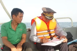 Lực lượng kiểm ngư Quảng Bình tuyên truyền cho ngư dân đang khai thác trên biển tuân thủ các quy định pháp luật về chống khai thác IUU. (Ảnh: Đức Thọ/TTXVN)