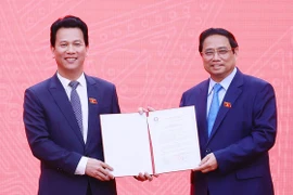 Thủ tướng Phạm Minh Chính trao Quyết định cho Bộ trưởng Bộ Tài nguyên và Môi trường Đặng Quốc Khánh. (Ảnh: Dương Giang/TTXVN)