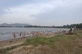 Rất đông người xuống tắm ở hồ Đại Lải, bất chấp cảnh báo nguy hiểm. (Nguồn: Vietnam+)