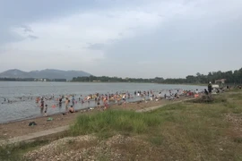 Rất đông người xuống tắm ở hồ Đại Lải, bất chấp cảnh báo nguy hiểm. (Nguồn: Vietnam+)
