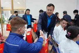 Công nhân Công ty Cổ phần Nhựa Hà Nội nhận quà của Chủ tịch Liên đoàn Lao động thành phố Hà Nội. (Ảnh: TTXVN phát)