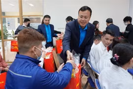 Công nhân Công ty Cổ phần Nhựa Hà Nội nhận quà của Chủ tịch Liên đoàn Lao động thành phố Hà Nội. (Ảnh: TTXVN phát)