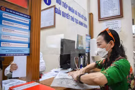 Người dân thực hiện thủ tục hành chính. (Nguồn: Vietnam+)