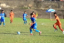 Cầu thủ đội PVF (áo xanh) quan sát để chuyền bóng cho đồng đội. (Ảnh: Thế Duyệt/TTXVN)