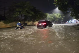 Các phương tiện di chuyển khó khăn trên đoạn đường ngập sâu ở thành phố Điện Biên Phủ. (Ảnh: Xuân Tư/TTXVN)