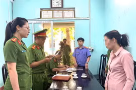 Cơ quan công an đọc quyết định khởi tố đối với đối tượng Đ.T.T. (Ảnh: TTXVN phát)