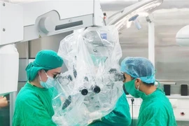 Các bác sỹ Bệnh viện Đa khoa tỉnh Thanh Hóa sử dụng kính vi phẫu để phẫu thuật cắt bỏ khối u não cho bệnh nhân. (Ảnh TTXVN phát)