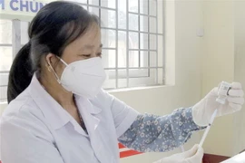 Lấy vaccine COVID-19 trước khi tiêm. (Nguồn: TTXVN)