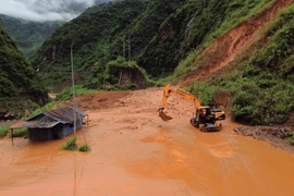 Máy múc được huy động để san gạt bùn, đất, đá bị sạt lở tại bản Nà Lếch, xã Chiềng Lao, huyện Mường La, tỉnh Sơn La. (Ảnh: Quang Quyết/TTXVN)