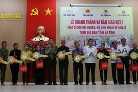 Thứ trưởng Bộ Công an Lương Tam Quang, lãnh đạo tỉnh Hà Tĩnh và nhà tài trợ Tập đoàn BRG, Ngân hàng SeABank trao tặng quà và biểu trưng chìa khóa nhà cho các hộ dân ở huyện Hương Khê. (Ảnh: Hoàng Ngà/TTXVN)